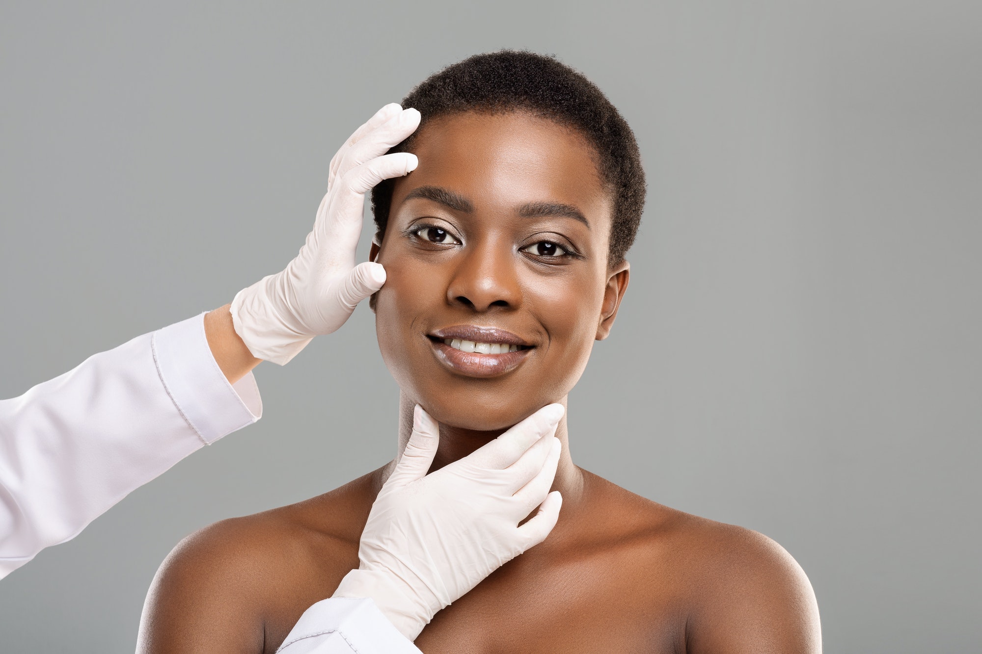 Beautiful black woman getting checking at cosmetology clinic